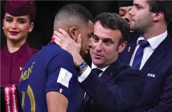  ?? LAPRESSE ?? Macron consuela a Mbappé tras perder la final del Mundial de Qatar ante Argentina.