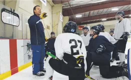  ??  ?? First-year Valor Christian hockey coach George Gwozdecky meets with his players during practice Thursday at The Ice Ranch.