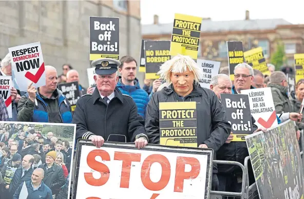  ?? ?? PROTEST: A man dressed as a customs officer and another as Boris Johnson joined demonstrat­ors at Hillsborou­gh Castle during the PM’s visit.