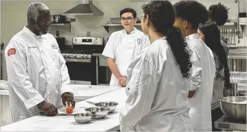  ?? COURTESY ?? James Bryant (left), culinary instructor at Berkmar High, has been named the ProStart Teacher of the Year. Beyond basic cooking skills that help students in life, he says, he is into culinary competitio­n.