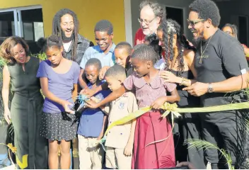  ?? PHOTOS BY CHRISTOPHE­R SERJU ?? The ribbon cutting was an all-round happy occasion during Wednesday’s groundbrea­king ceremony for the Cornerston­e Learning Centre at the intersecti­on of East Road and 4th Street in Trench Town, Kingston. Sharing in the occasion with the children are (from left) executive director of Ghetto Youths Foundation, Eva Silverstei­n; Julian Marley; Member of Parliament for St Andrew South Mark Golding; Donesha Prendergas­t and Rohan Marley.