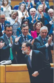  ?? AP/PAUL WHITE ?? Spanish senators applaud Prime Minister Mariano Rajoy on Friday after he spoke out against Catalonia’s move for secession. The Senate granted him special powers to stop the move.