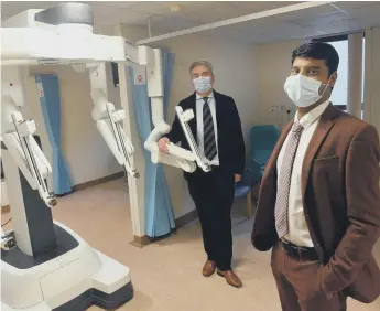  ??  ?? Urology consultant cancer lead Kanagasaba­i Sahadevan, clinical director of urology Stuart McCracken and the robot.