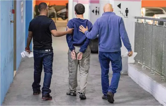  ??  ?? Jack Guez / AFP / Getty Images An American-Israeli Jewish teen, accused of making dozens of anti-Semitic bomb threats in the United States and elsewhere, is escorted by guards as he leaves the Israeli Justice court in Rishon Lezion on Thursday.