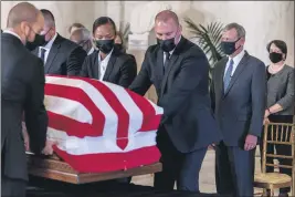  ?? ANDREW HARNIK — THE ASSOCIATED PRESS ?? Chief Justice of the United States John Roberts, second from right, and Justice Elena Kagan, right, watch as the flag-draped casket of Justice Ruth Bader Ginsburg arrives at the Supreme Court in Washington on Wednesday.