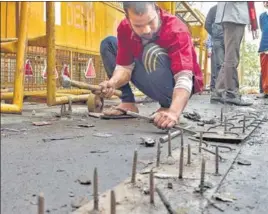  ?? PTI ?? A worker uproots spikes placed to block farmers at Ghazipur border. Police said the spikes were not being removed from the site, instead they were being “reposition­ed”.