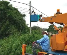  ??  ?? Photo shows a streetligh­t being installed in the Batu Kawah area.