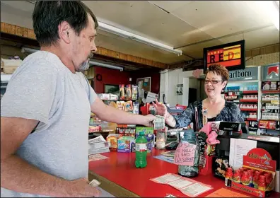  ?? NWA Media/DAVID GOTTSCHALK ?? Mary Dearing collects payment for a drink from Terry Daniels at Hogeye Mall. Daniels, who stops by frequently, said he didn’t want to see the store “go away.”