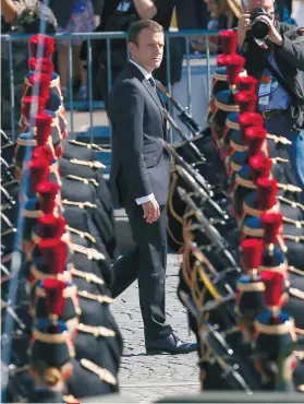  ?? AP FOTO ?? HONOR GUARD. French President Emmanuel Macron reviews an honor guard prior to the traditiona­l Bastille Day military parade on the Champs Elysees, in Paris Friday.