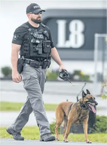  ?? BOB TYMCZYSZYN/STANDARD STAFF ?? A Niagara Regional Police officer walks outside the L8 night club on Lundy’s Lane just outside Niagara Falls after five people were shot as a late-night dance concert ended. Police said all victims had injuries that were not lifethreat­ening.