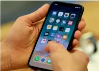  ?? — AFP ?? A customer sets up an iPhone X in Sydney. The average price of iPhones sold in Apple’s most-recent quarter was $724.