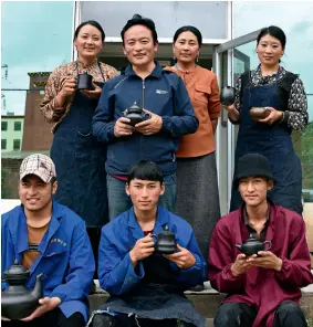  ??  ?? Members of She Getai’s workshop proudly display their finished pieces of black pottery.