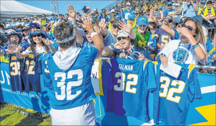  ?? Mark Rightmire The Orange County Register ?? Chargers safety Alohi Gilman greets fans at the fence as the team held its first practice of training camp in Costa Mesa, Calif., late last month.