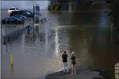  ?? MATT ROURKE — THE ASSOCIATED PRESS ?? People view a flooded street in Philadelph­ia on Thursday in the aftermath of downpours and high winds from the remnants of Hurricane Ida.