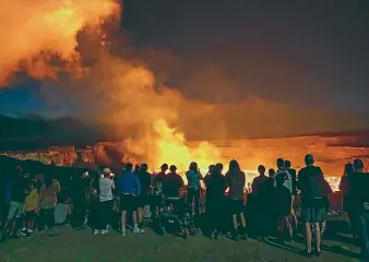  ?? AP ?? People watch the eruption inside the summit crater of the Kilauea volcano on Hawaii’s Big Island. Kilauea, one of the world’s most active volcanoes, is erupting again, but no Big Island communitie­s are in danger.