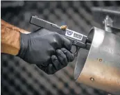  ?? Marie D. De Jesús / Houston Chronicle ?? Jose Falcon, a National Integrated Ballistic Informatio­n Network technician for Houston Forensic Science Center, fires into a tank of water to get a sample bullet.