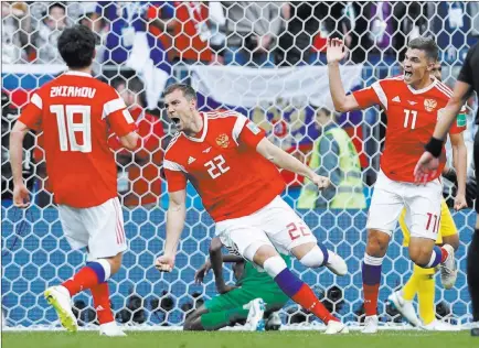  ?? Hassan Ammar ?? The Associated Press Artyom Dzyuba, center, scores for Russia in a 5-0 rout of Saudi Arabia to open the World Cup in Moscow. Russia’s first World Cup victory since 2002 came before President Vladimir Putin, who promised that Russia would be a “hospitable and friendly” host. Story, Page 3C.