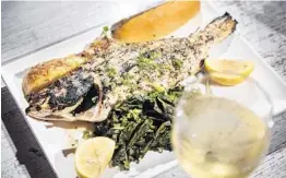  ?? BENJAMIN RUSNAK ?? Grilled whole red snapper with ladolemono sauce, wild greens and lemon potatoes is one of the new dishes at Taverna Opa in Delray Beach.