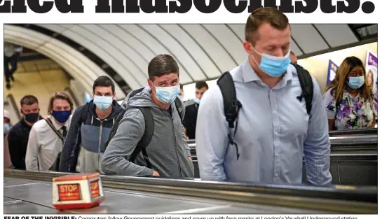  ??  ?? fear of the invisible: Commuters follow Government guidelines and cover up with face masks at London’s Vauxhall Undergroun­d station