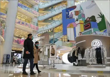  ?? ANDY WONG — THE ASSOCIATED PRESS FILE ?? Shoppers walk through a reopened shopping mall after authoritie­s started easing some of the anti-virus controls in Beijing on Dec. 6, 2022. Chinese manufactur­ing weakened for a third consecutiv­e month in December, in the biggest drop since early 2020, as the country battles a nationwide COVID-19 surge after suddenly easing its anti-epidemic measures.