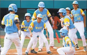  ?? Gene J. Puskar / Associated Press ?? Hawaii’s Mana Lau Kong (19) is greeted by teammates after hitting the first pitch of Sunday’s game against South Korea for a home run in the Little League World Series Championsh­ip in South Williamspo­rt, Pa.