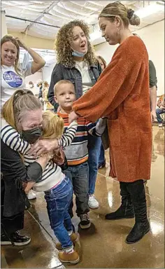  ?? ?? During Thursday’s Thanksgivi­ng meal, volunteer Vicky Hardy hugs Kendall, daughter of Courtney Mairel, who is holding her daughter’s hand and is going through the women’s and children’s program at The Mission.