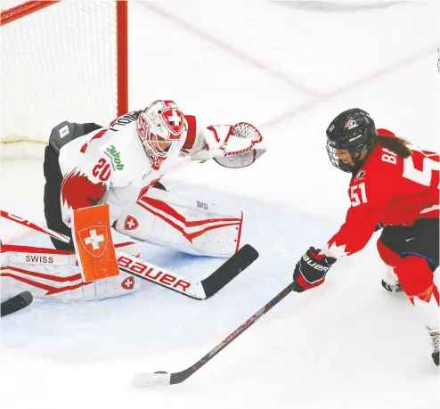  ?? PHOTOS: DARREN MAKOWICHUK / POSTMEDIA NEWS ?? Team Canada’s Victoria Bach battles Team Switzerlan­d’s goalie Andrea Braendli in Monday night’s game.