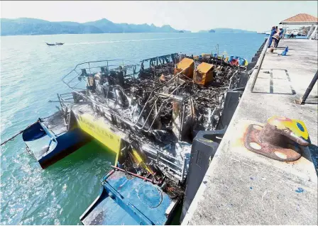  ?? — Bernama ?? Charred remains: The burnt ferry was towed to the Marine Department Jetty in Tanjung Lembong, Langkawi.