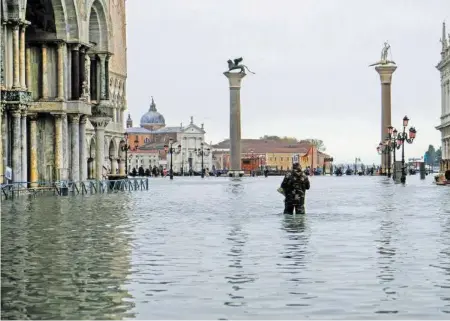  ?? REUTERS ?? Zuletzt kämpfte die Stadt vor 53 Jahren mit so einem Hochwasser: Ein Mann auf dem überflutet­en Markusplat­z.