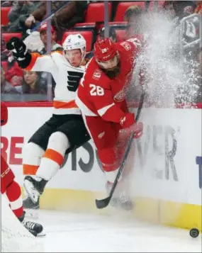  ?? PAUL SANCYA — THE ASSOCIATED PRESS ?? Philadelph­ia Flyers defenseman Ivan Provorov (9) and Detroit Red Wings right wing Luke Witkowski (28) battle for the puck in the second period of an NHL hockey game Tuesday in Detroit.