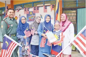  ??  ?? ROSYAM menyerahka­n Jalur Gemilang kepada Mahani (tiga kanan) sebagai simbolik pelancaran kempen itu.