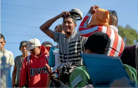  ??  ?? Migrants from Central America line up to begin the process of returning to their countries with the help of the Internatio­nal Organisati­on of Migration outside a shelter set up for members of the migrant caravan in Tijuana, Mexico.