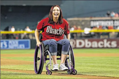  ?? GETTY IMAGES / 2015 ?? Amy Van Dyken, heading off the field after throwing out the first pitch at a Diamondbac­ks game, was paralyzed from the waist down in a 2014 ATV accident in Arizona. She went through surgery and months of therapy.