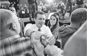  ?? STEVEN SENNE/ASSOCIATED PRESS ?? Former South Bend, Ind., Mayor Pete Buttigieg, center, who led the delegate count in the Iowa Democratic presidenti­al caucus, greets people at a rally Sunday in Dover, N.H.