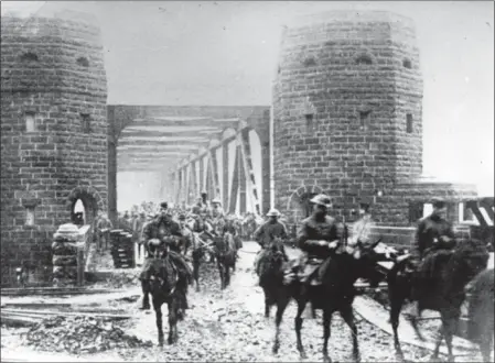  ?? PHOTO PROVIDED ?? U.S. Army National Guard soldiers assigned to the 165th Infantry Regiment, 42nd Division, pass through the Ludendorff Bridge at Remagen, Germany as they assume occupation duties on Dec. 13, 1918. The 42nd Division, known as the Rainbow Division for its inclusion of various National Guard units from across the United States, served as an occupation force in the Rhineland following the armistice that ended World War I. The division served in Germany until April 1, 1919, when it embarked for its journey home.