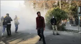  ?? THE ASSOCIATED PRESS ?? In this photo taken by an individual not employed by the Associated Press and obtained by the AP outside Iran, university students attend a protest inside Tehran University while a smoke grenade is thrown by anti-riot Iranian police, in Tehran, Iran,...