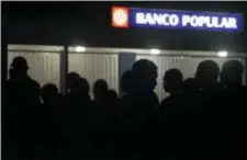  ?? CARLOS GIUSTI — THE ASSOCIATED PRESS ?? Clients of Popular Bank of Puerto Rico wait in line at the Carolina Shopping Court branch to withdraw cash from their accounts after the passage of Hurricane Maria, in Carolina, Puerto Rico, Wednesday. Because of the communicat­ions blackout caused by...