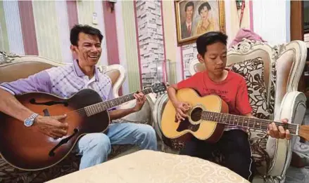  ??  ?? Bermain gitar bersama anak bongsunya, Amri Farizuan.