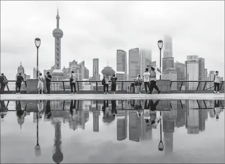  ?? WANG GANG / FOR CHINA DAILY ?? Above: Rainwater creates a mirror image of skyscraper­s in Lujiazui, Shanghai, on June 10.