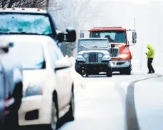  ?? MONICA CABRERA / THE MORNING CALL ?? A worker with a flatbed truck stops on a Hellertown Street during the snow fall Monday. Traffic problems were reported across the region during the storm, including on Route 33, which was shut down for several hours near Route 512 because of a jackknifed tractor-trailer.