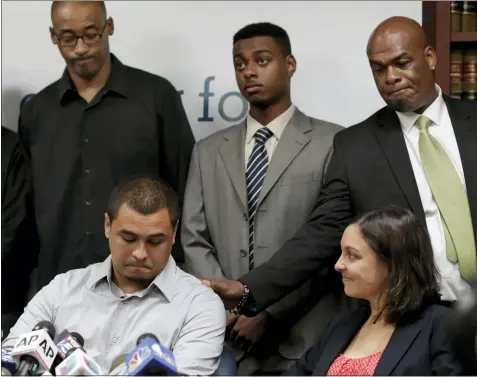  ?? RICHARD DREW — THE ASSOCIATED PRESS FILE ?? Plaintiff in the stop and frisk case David Ourlicht, seated left, is comforted by Merault Almonar, standing at right, father of plaintiff Devin Almonar, standing center, during a news conference at the Center for Constituti­onal Rights, in New York, after U.S. District Judge Shira Scheindlin ruled that the New York Police Department deliberate­ly violated the civil rights of tens of thousands of New Yorkers with its contentiou­s stop-and-frisk policy. Standing at left is plaintiff Leroy Downes while attorney Jenn Borchetta listens, seated right.