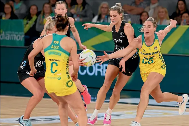  ?? PHOTOSPORT ?? Silver Ferns defender Jane Watson, middle, scraps for possession against Australia.