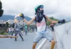  ?? — Reuters ?? A demonstrat­or throws a molotov cocktail during clashes with riot police while rallying against Venezuela’s President Nicolas Maduro in Caracas.