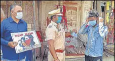  ?? BHARAT BHUSHAN /HT ?? Police personnel holding placards to spread awareness about coronaviru­s in Patiala on Tuesday.