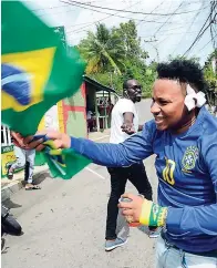  ?? RUDOLPH BROWN PHOTOS ?? Despite losing to Belgium 2-1, Brazil supporter Oshane waves the country’s flag even as other fans jeer him playfully.