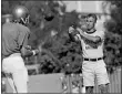  ?? GB — THE ASSOCIATED PRESS FILE ?? UCLA quarterbac­k Mark Harmon, left, son of former Michigan Heisman Trophy winner Tom Harmon, works out with coach Pepper Rodgers, right, in Los Angeles in 1972.