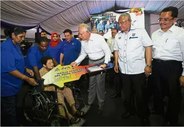  ??  ?? Home, sweet home: Najib handing over a mock key to a new PPR resident as (from third left) Tan Sri Shahrizat Abdul Jalil, Tengku Adnan, Noh and Urban Wellbeing, Housing and Local Government secretaryg­eneral Datuk Mohammad Mentek look on. — Bernama