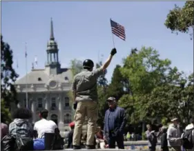  ?? MARCIO JOSE SANCHEZ — THE ASSOCIATED PRESS ?? A demonstrat­or raises a U.S. flag Thursday in Berkeley Demonstrat­ors gathered near the University of California, Berkeley campus amid a strong police presence and rallied to show support for free speech and condemn the views of Ann Coulter and her...