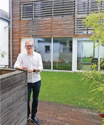  ??  ?? Hier treffen Passion und Profession zusammen: Jörg Wollenwebe­r steht vor seinem Holzhaus in einem stillen Oberbilker Hinterhof – er ist Professor für Holzbauwei­se an der Uni Aachen.