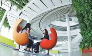  ?? CUI XIAO / FOR CHINA DAILY ?? Two visitors enjoy their time at the serene Green Lighthouse in Nanjing, Jiangsu province. The environmen­tally friendly Sino-Danish project is a cylinder-shaped three-story building with an undergroun­d floor and allows sunlight to filter in from the...
